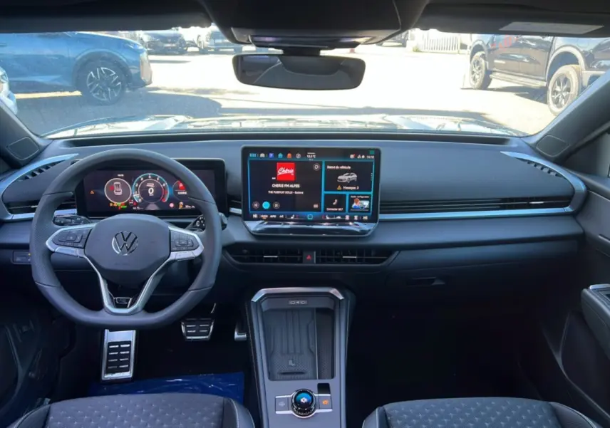 Intérieur noir du Volkswagen T-Roc 2026 vu de face, avec tableau de bord digital et écran tactile central.