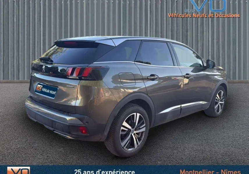 Peugeot 3008 gris foncé vue 3/4 arrière droit, jantes alliage 18 pouces et vitres teintées sur fond neutre.