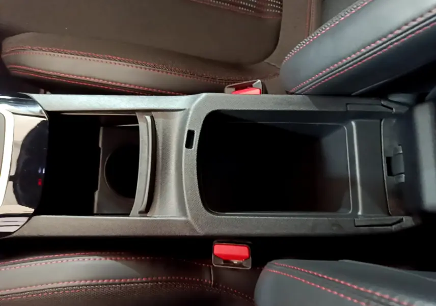 Vue plongeante sur la console centrale ouverte de la Peugeot 308 GT Line 2016, sièges noirs avec surpiqûres rouges.