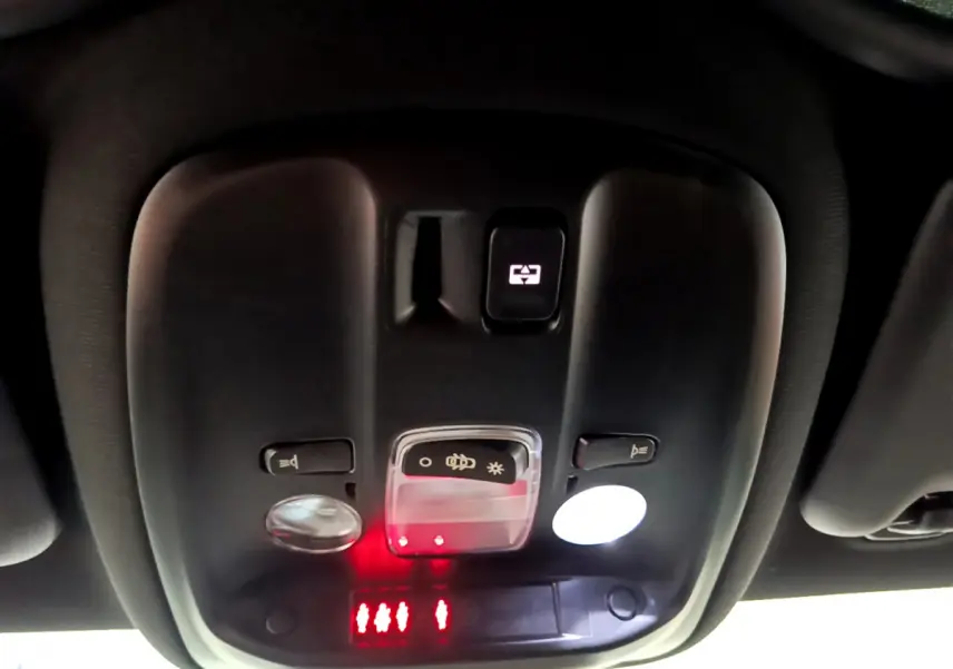 Vue en gros plan du plafonnier noir avec commandes d'éclairage et indicateurs rouges dans une Peugeot 308 gris foncé 2016.