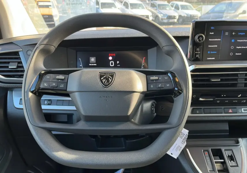 Vue intérieure centrée sur le volant multifonctions du Peugeot Traveller 2025 avec tableau de bord digital et écran tactile.