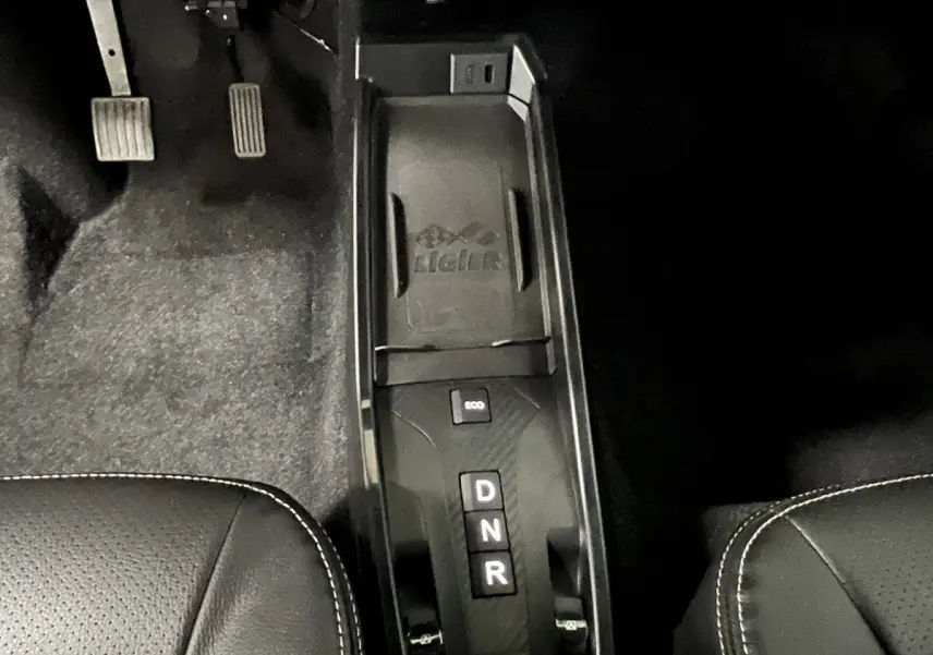 Vue rapprochée du levier de vitesses automatique noir et des pédales côté conducteur dans l’habitacle du Ligier JS50 rouge.