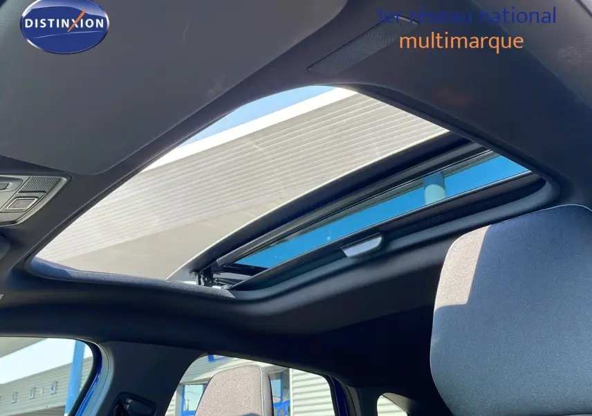 Toit ouvrant panoramique ouvert sur l'intérieur d'un Renault Captur E-Tech hybride 2025 bleu iron metal.