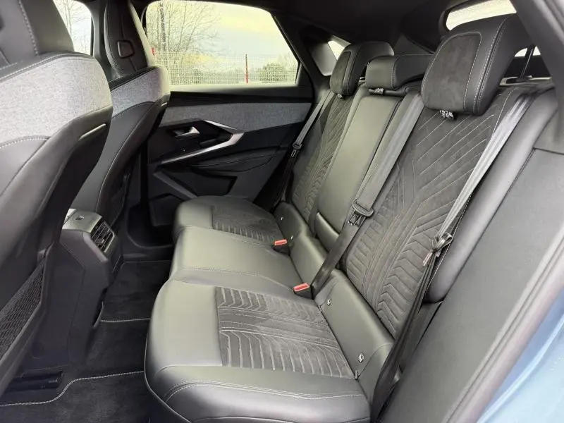 Vue latérale droite de la banquette arrière en cuir et tissu Alcantara gris du Peugeot 3008 électrique bleu 2024.