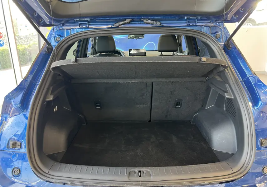 Coffre ouvert vu de l'arrière d'un SERES 3 Electric bleu astral métallisé, montrant l'espace de chargement vide.