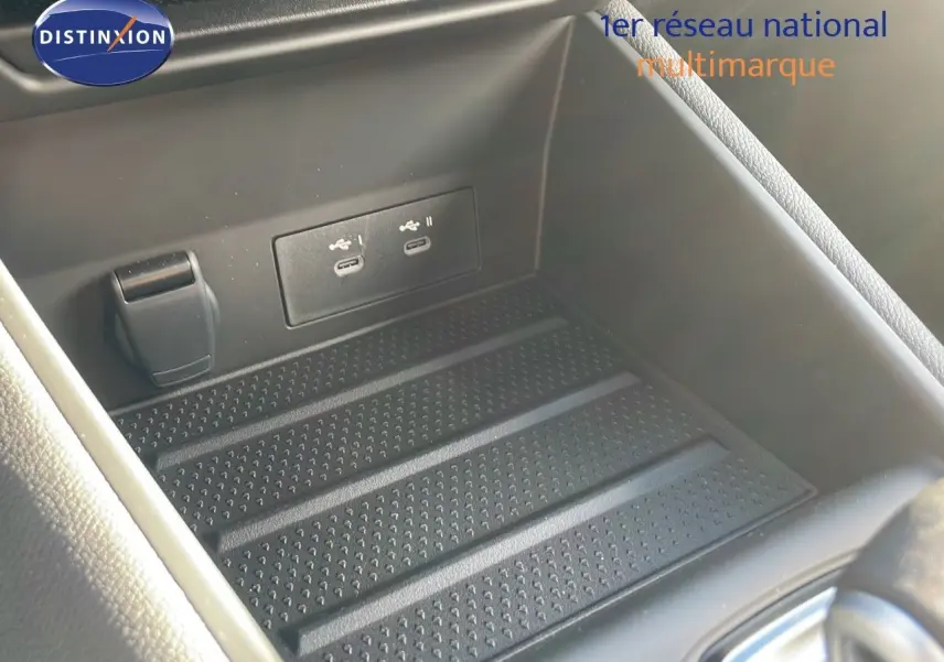 Gros plan sur la console centrale du Renault Captur E-Tech avec deux ports USB-C et un espace de rangement noir.