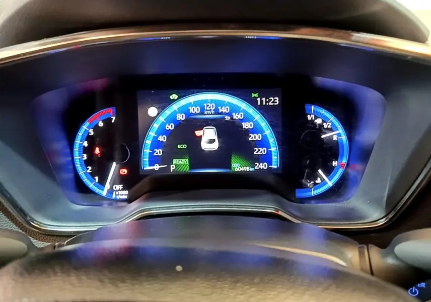 Vue rapprochée du tableau de bord numérique bleu de la Toyota Corolla Hybride 2021, affichant la vitesse et l'heure.
