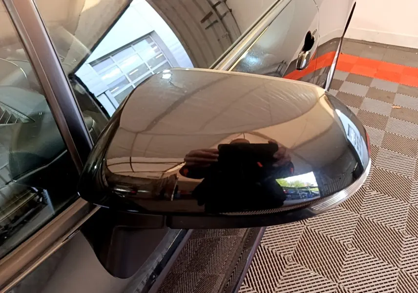 Rétroviseur côté gauche noir brillant de la Toyota Corolla hybride 2021, avec clignotant intégré visible.