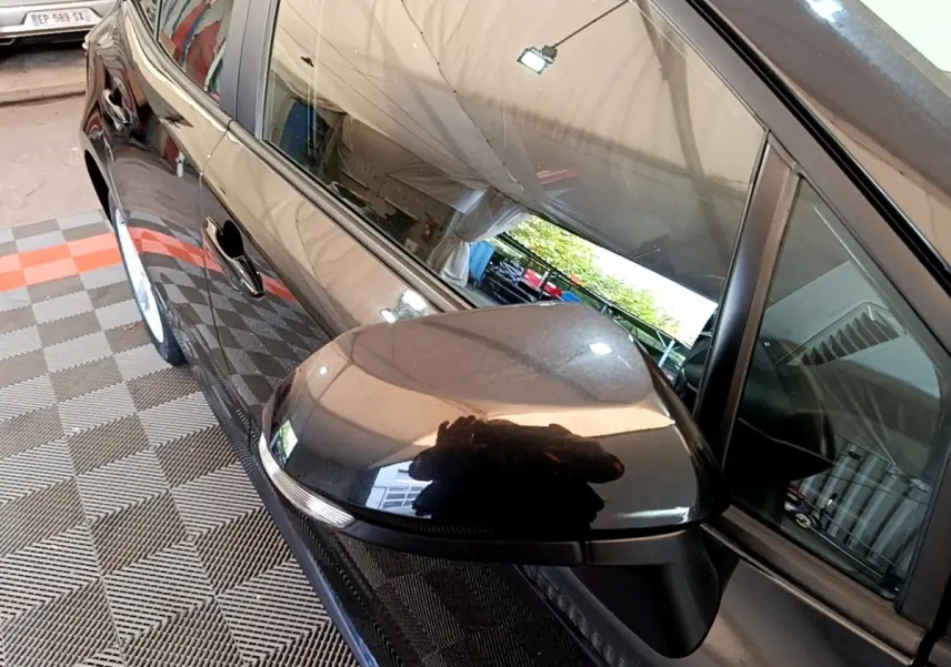 Rétroviseur côté gauche noir brillant de la Toyota Corolla hybride 2021, vue rapprochée sur la portière avant.