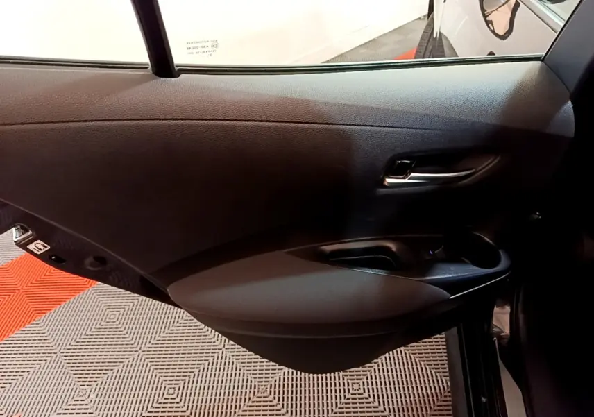 Porte arrière droite noire de Toyota Corolla hybride 2021, montrant la poignée et les commandes de fenêtre.