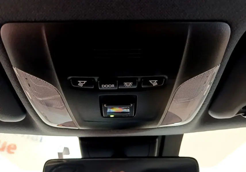 Vue intérieure du plafonnier noir de la Toyota Corolla hybride 2021 avec commandes d'éclairage et détecteur intégré.