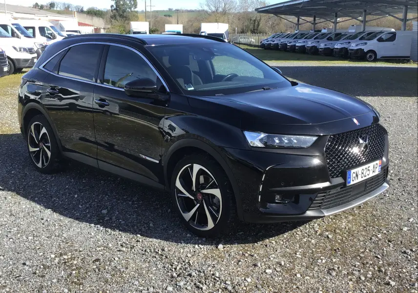 DS7 Crossback noir en 3/4 avant droit, mettant en valeur sa calandre distinctive et ses jantes bicolores élégantes.