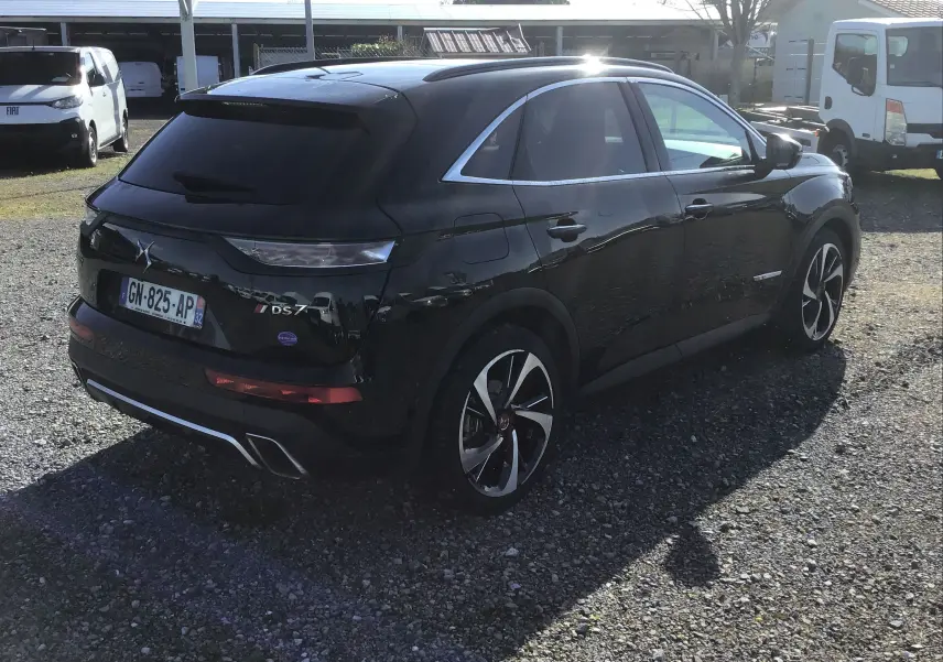 Vue 3/4 arrière droite du DS7 Crossback noir 2023 avec jantes alliage distinctives et feux arrière effilés.