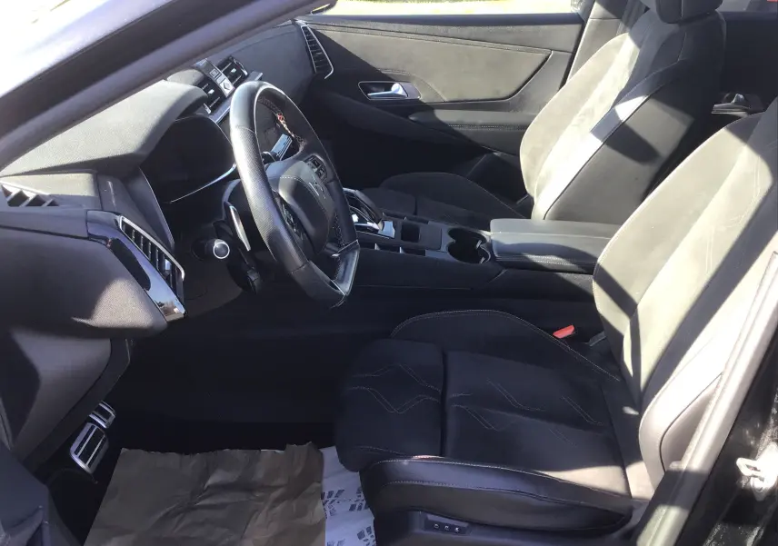 Vue intérieure côté conducteur du DS7 Crossback noir 2023, mettant en valeur les sièges en cuir et alcantara ainsi que le volant multifonction.