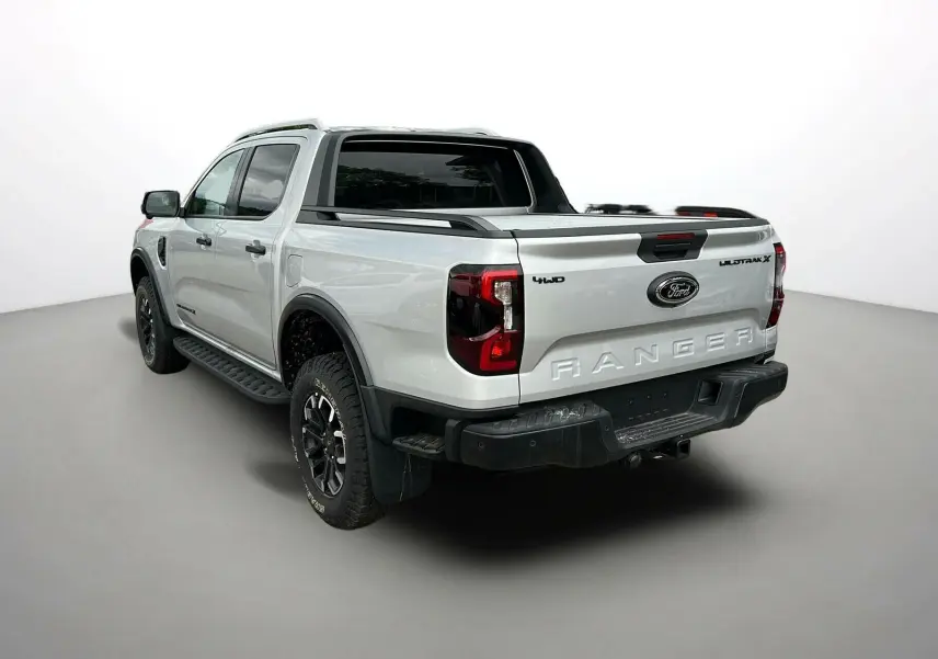 Ford Ranger Wildtrak gris iconic vu en 3/4 arrière droit avec benne et barres de toit noires.