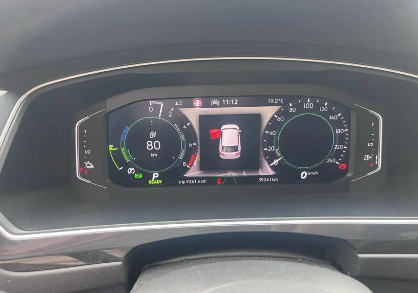 Tableau de bord numérique du Volkswagen Tiguan 1.4 eHybrid 2023 affichant vitesse, autonomie et alertes.
