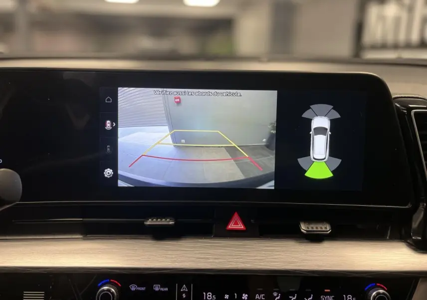 Écran tactile du tableau de bord du KIA SPORTAGE 2022 montrant la caméra de recul et l'assistance au stationnement.