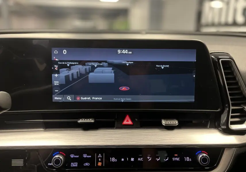 Tableau de bord du KIA SPORTAGE 2022 avec écran tactile GPS et commandes de climatisation affichant 18,5°C.