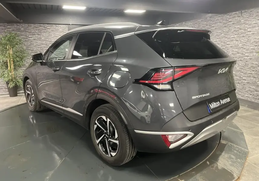 Vue 3/4 arrière droite du KIA Sportage gris métallisé avec jantes alliage et feux arrière LED distinctifs.