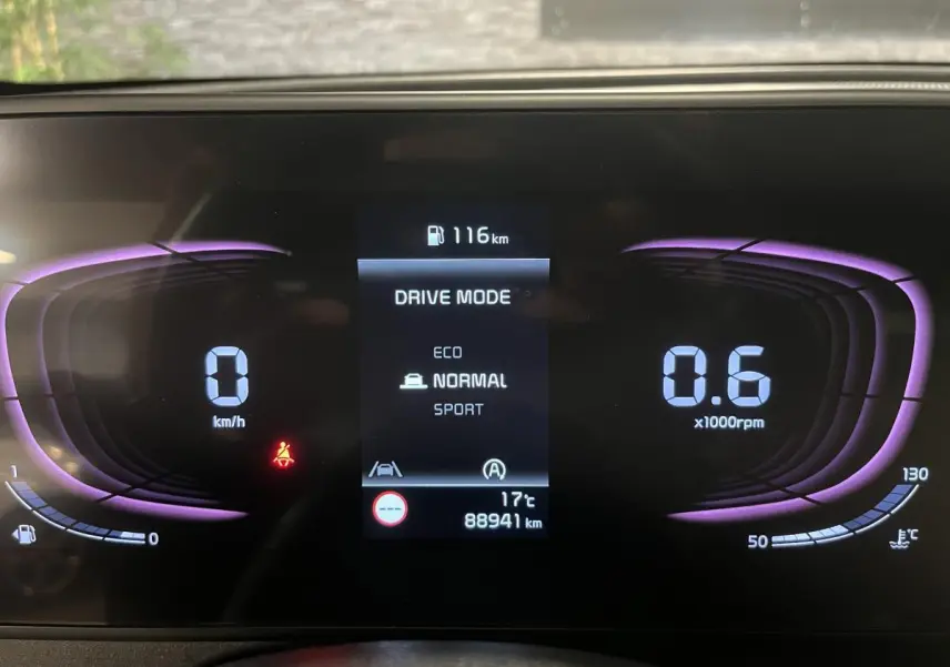 Tableau de bord numérique du Kia Sportage gris 2022 affichant mode de conduite et compte-tours violet.