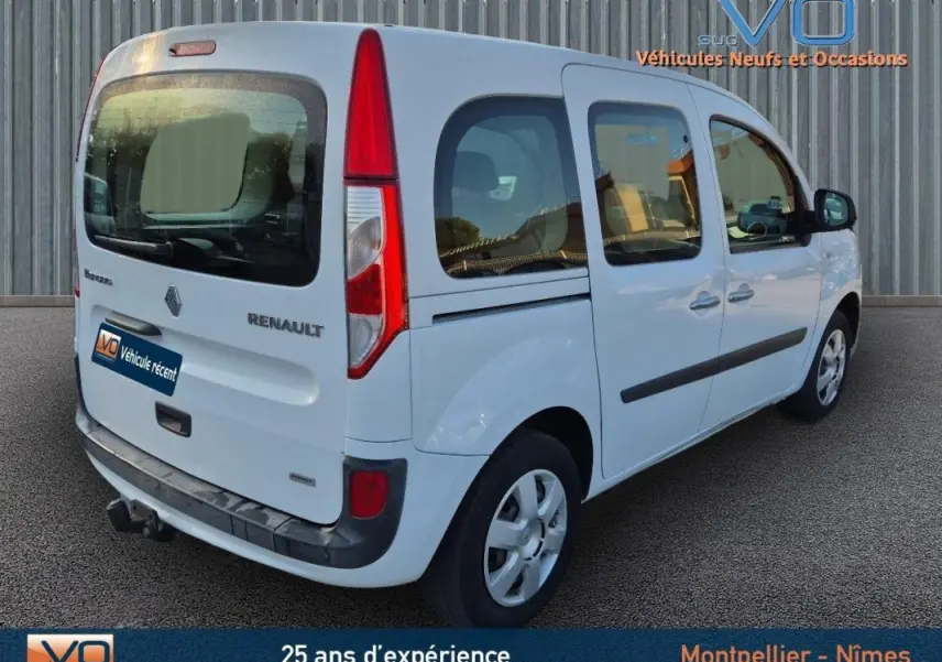 Renault Kangoo blanc vu en 3/4 arrière droit, avec vitres surteintées et porte latérale coulissante visible.