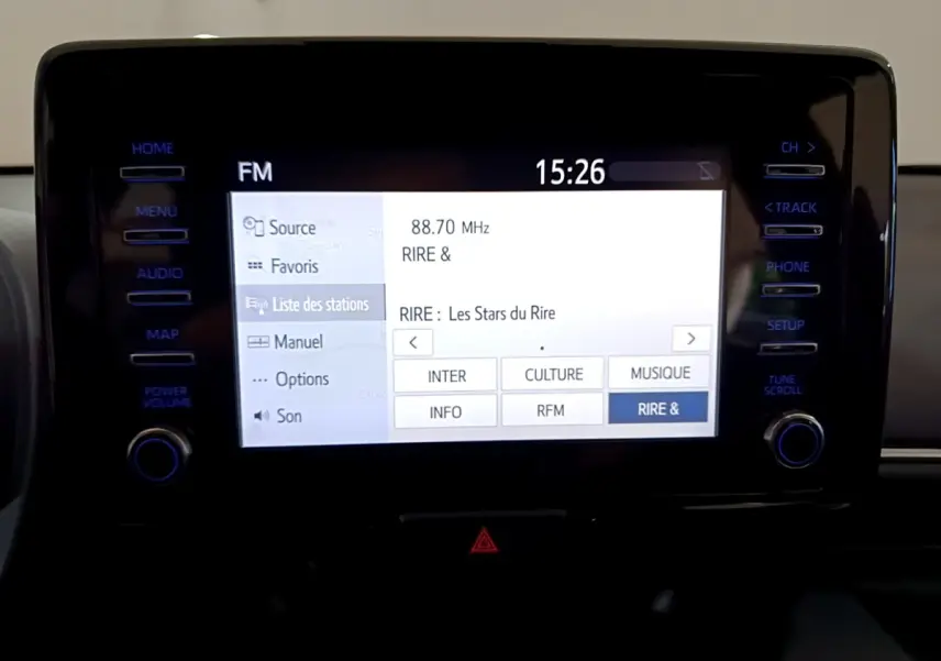 Écran tactile central allumé de la Toyota Yaris hybride 2021, affichant la liste des stations radio FM.