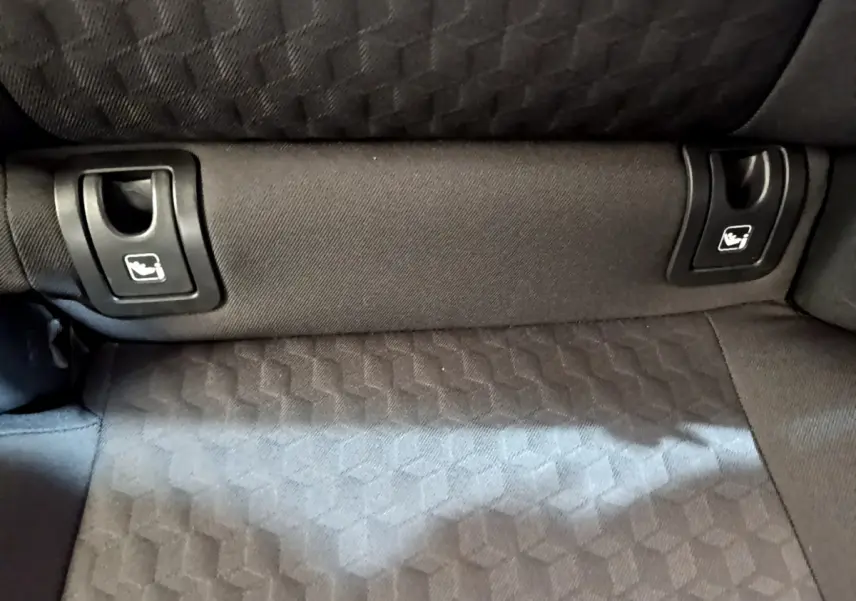 Gros plan sur la banquette arrière gris foncé de la Toyota Yaris hybride, montrant les attaches Isofix intégrées.