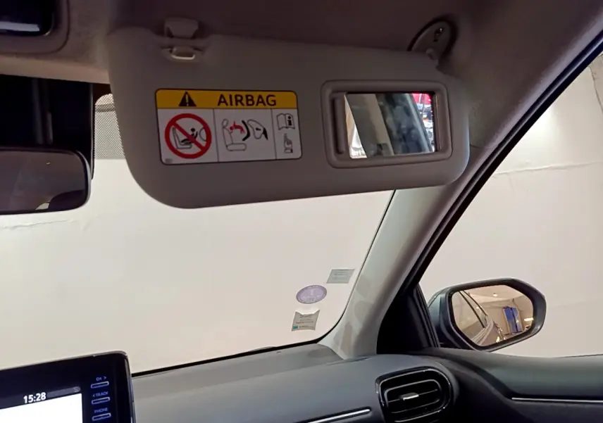 Détail intérieur sur le pare-soleil côté conducteur de la Toyota Yaris hybride 2021 avec miroir et avertissement airbag.