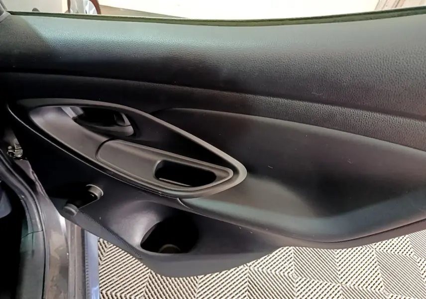 Vue rapprochée de la porte côté gauche noire de la Toyota Yaris Hybride 116h 2021 avec poignée intégrée et rangement.