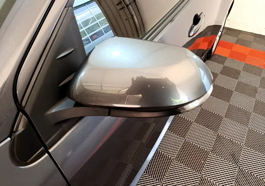 Rétroviseur côté gauche gris clair de la Toyota Yaris hybride 2021, avec poignée de porte et reflet intérieur visible.