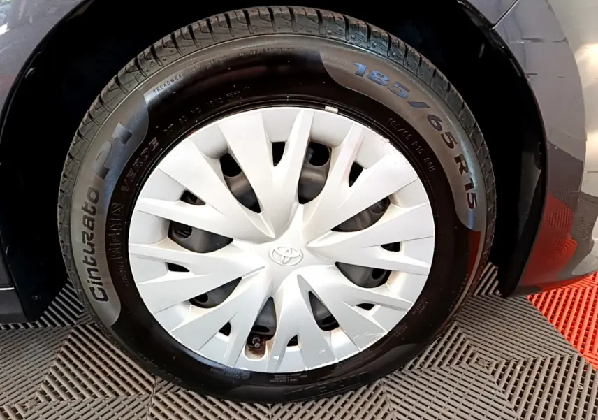Gros plan sur la roue avant gauche grise d'une Toyota Yaris hybride 2021 avec enjoliveur blanc et pneu Cinturato P1.