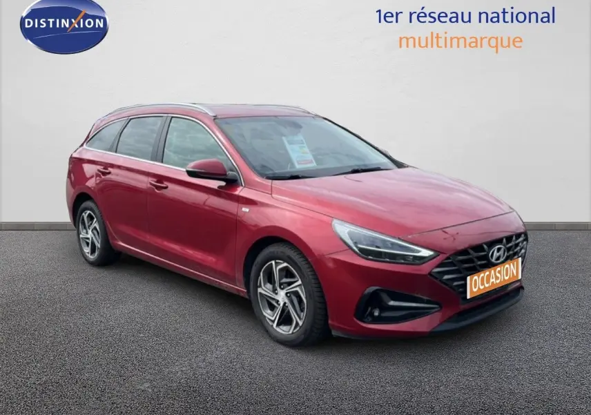 Hyundai i30 SW rouge Sunset Red vue 3/4 avant droit, avec calandre noire et jantes alliage bicolores.