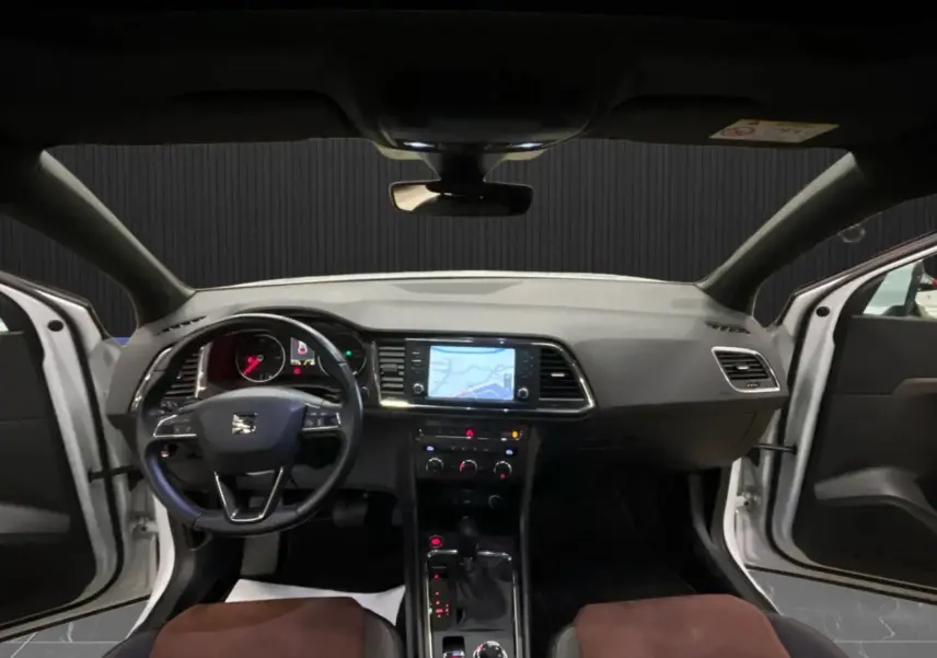 Vue intérieure avant du SEAT Ateca blanc 2016, tableau de bord avec écran tactile et volant multifonction.