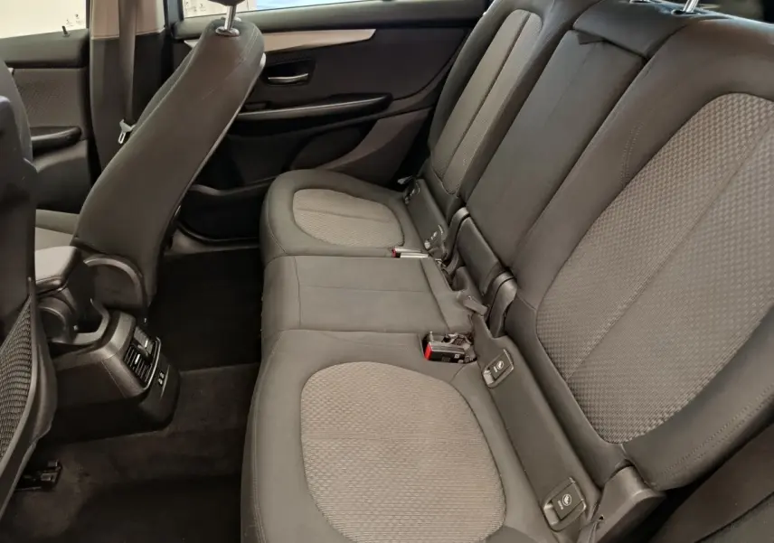 Vue intérieure côté droit des sièges arrière gris foncé avec appuie-têtes et ceintures de sécurité visibles dans une BMW Série 2 Gran Tourer.