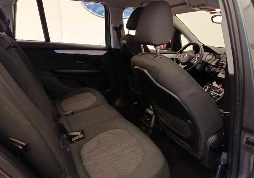 Vue intérieure côté gauche montrant les sièges arrière et le poste de conduite d'une BMW Série 2 Gran Tourer gris clair.