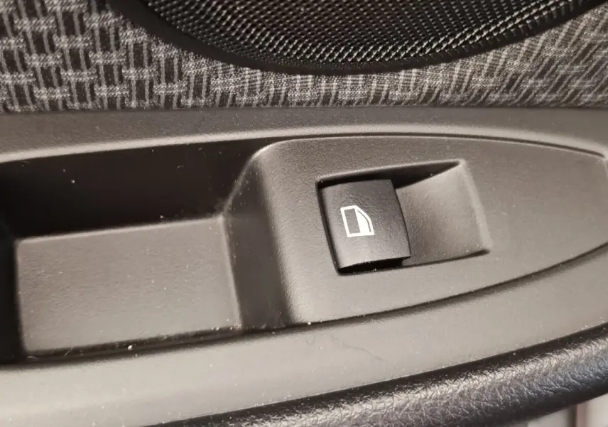 Bouton de commande de lève-vitre noir sur panneau de porte intérieur tissu gris de BMW Série 2 Gran Tourer F46.