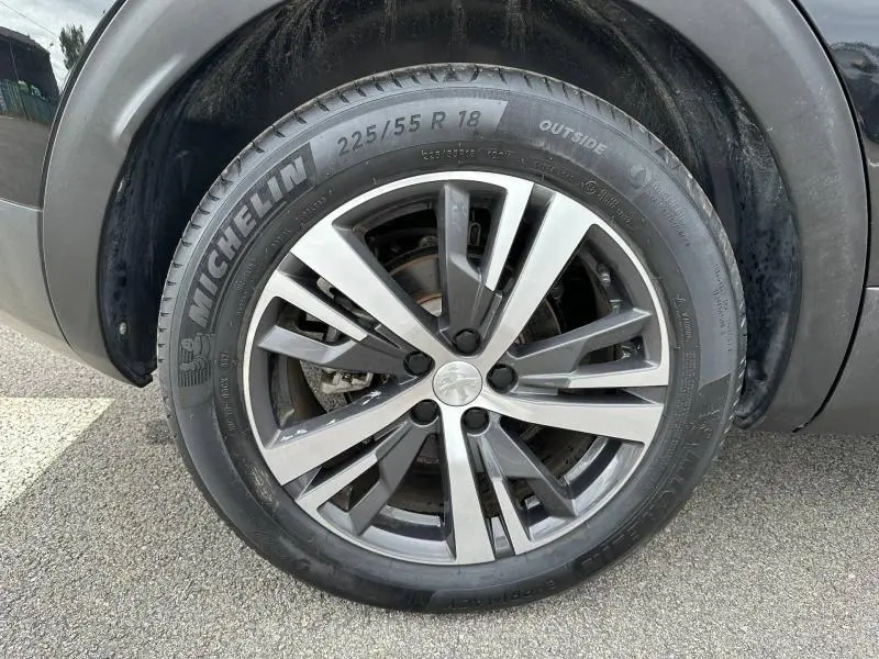 Gros plan sur la roue avant gauche du Peugeot 3008 noir Perla Nera avec jante alu et pneu Michelin.