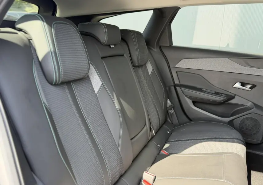 Vue latérale droite des sièges arrière en sellerie tri matières noire avec surpiqûres bleues du Peugeot 308 SW 2025.