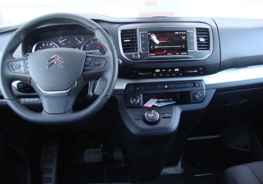 Vue intérieure du tableau de bord et volant noir du Citroën Jumpy Cabine Approfondie gris platinium, avec écran tactile central.