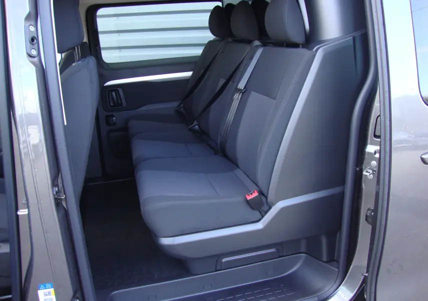 Vue latérale intérieure montrant les sièges arrière noirs du Citroën Jumpy Cabine Approfondie gris platinum 2024.