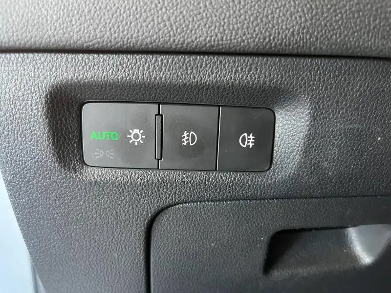 Gros plan sur les commandes d'éclairage noires avec fonction auto activée dans une Skoda Octavia Combi blanche Cristal spéciale 2022