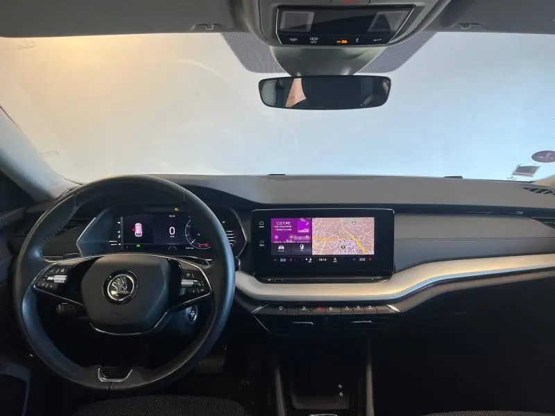 Intérieur avant de la Skoda Octavia Combi 2022, tableau de bord noir avec écran tactile et volant multifonction.