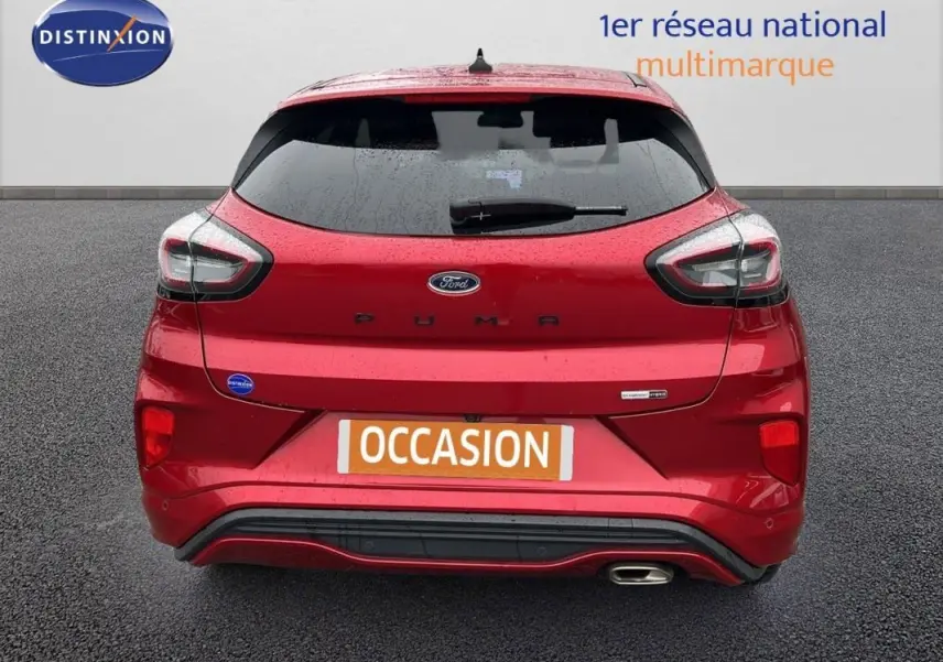Vue arrière d'une Ford Puma rouge 2020 avec feux LED et sortie d'échappement chromée visible sur fond gris.