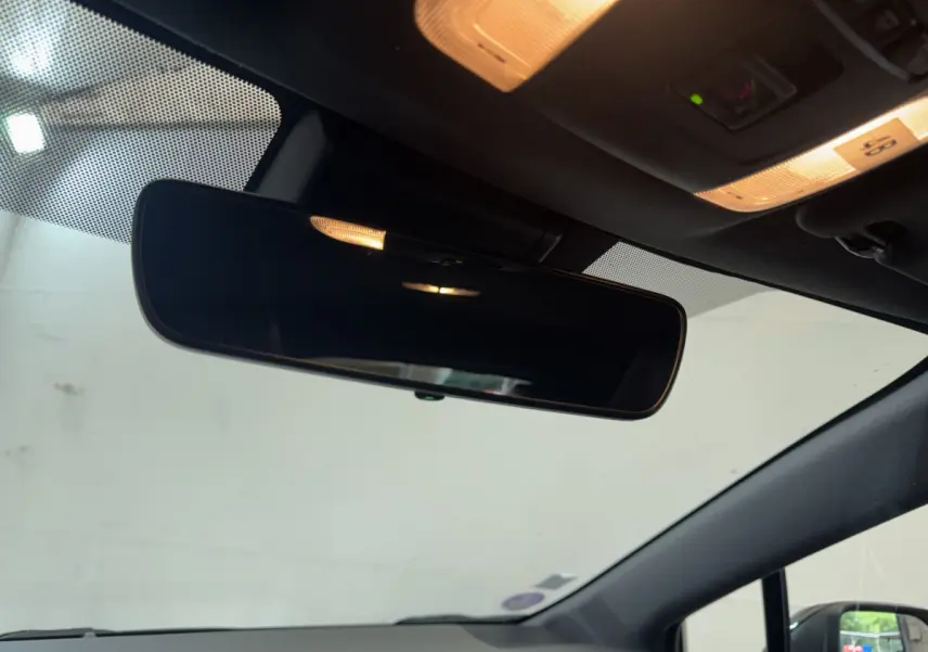 Rétroviseur intérieur et plafonnier éclairé dans l’habitacle sombre d’une Toyota Corolla Hybride 122h Collection 2021.