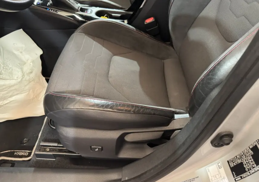 Gros plan sur le siège avant droit gris et noir avec surpiqûres rouges de la Toyota Corolla Hybride 122h Collection 2021.