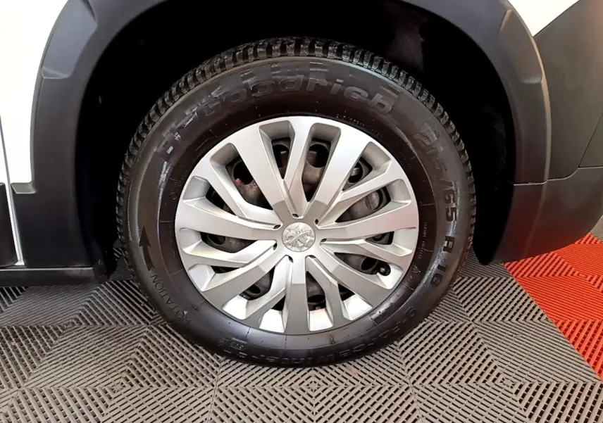 Gros plan sur la roue avant droite du Peugeot Rifter blanc, mettant en valeur la jante argentée et le pneu BFGoodrich.