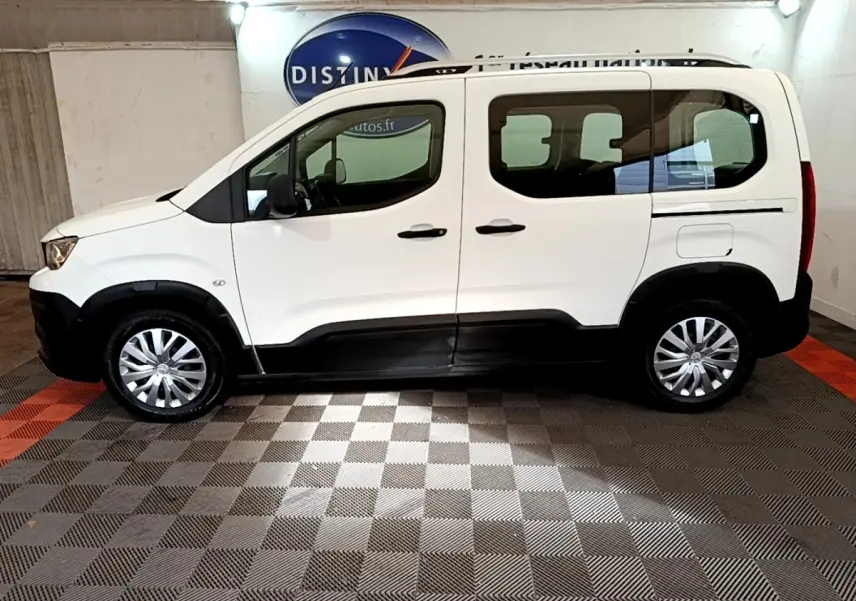 Peugeot Rifter blanc vue de profil côté gauche, avec protections noires sur bas de caisse et roues argentées.