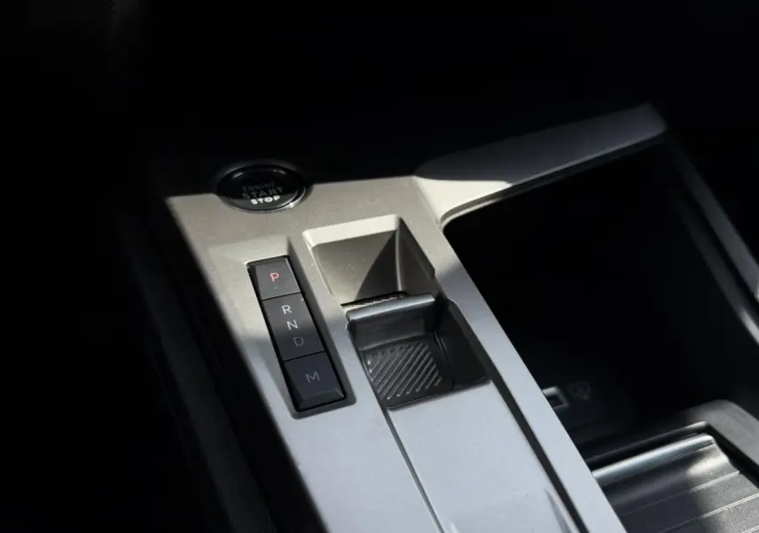 Gros plan sur la console centrale argentée du Peugeot 308 SW 2025 avec boutons de boîte auto et bouton start/stop.