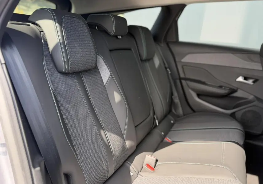Vue intérieure des sièges arrière en sellerie tri matières noire et tissu avec surpiqûres bleues du Peugeot 308 SW 2025.