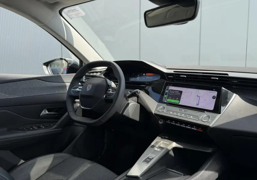 Vue intérieure côté conducteur du Peugeot 308 SW 2025 gris Artense, avec tableau de bord digital et écran tactile central.